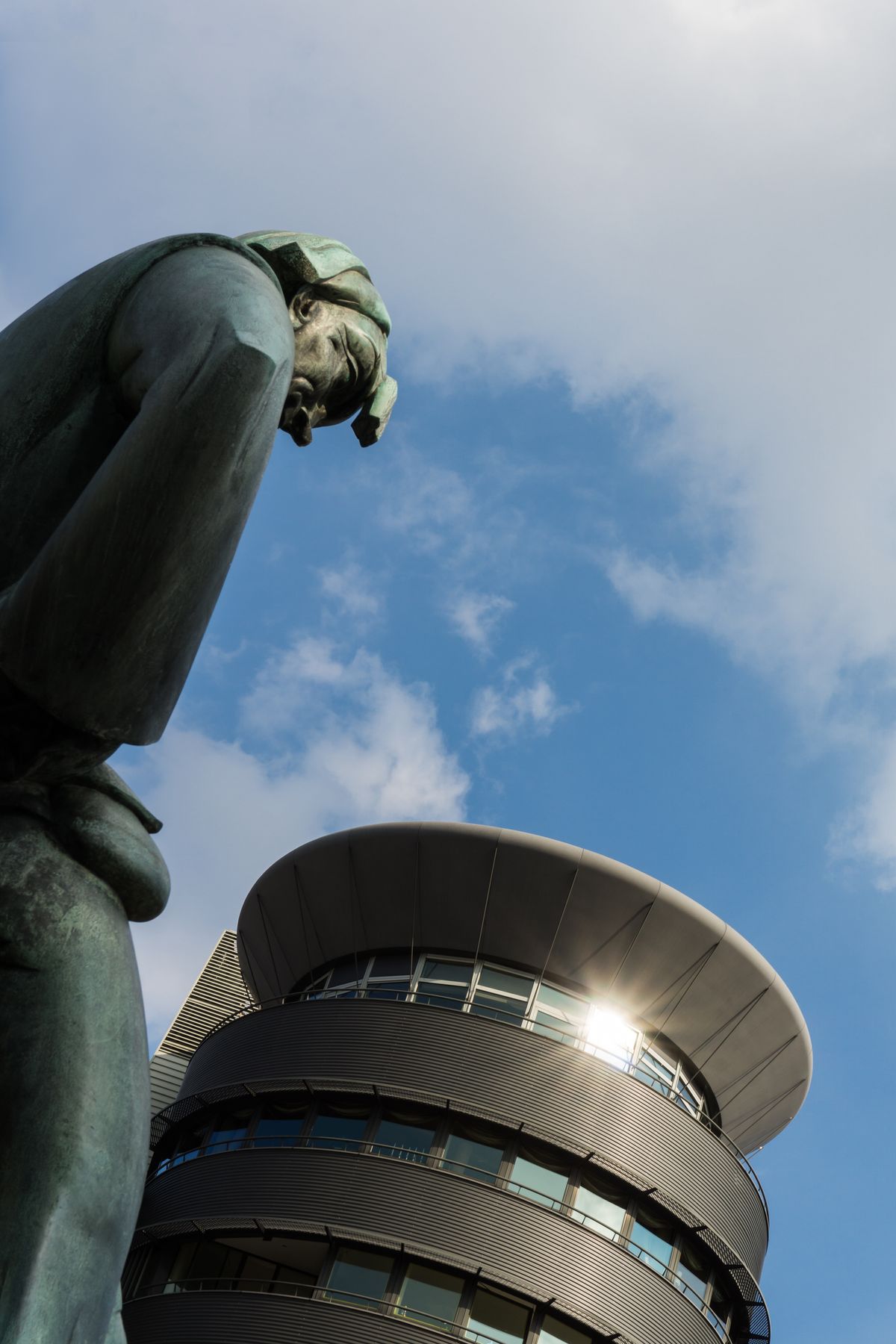 The statue of Lange Wapper is overlooking the modern architecture of the new building